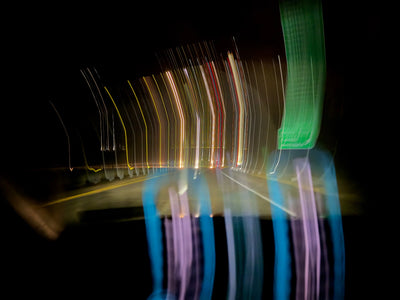 Long exposure night road with colorful light trails and reflections
