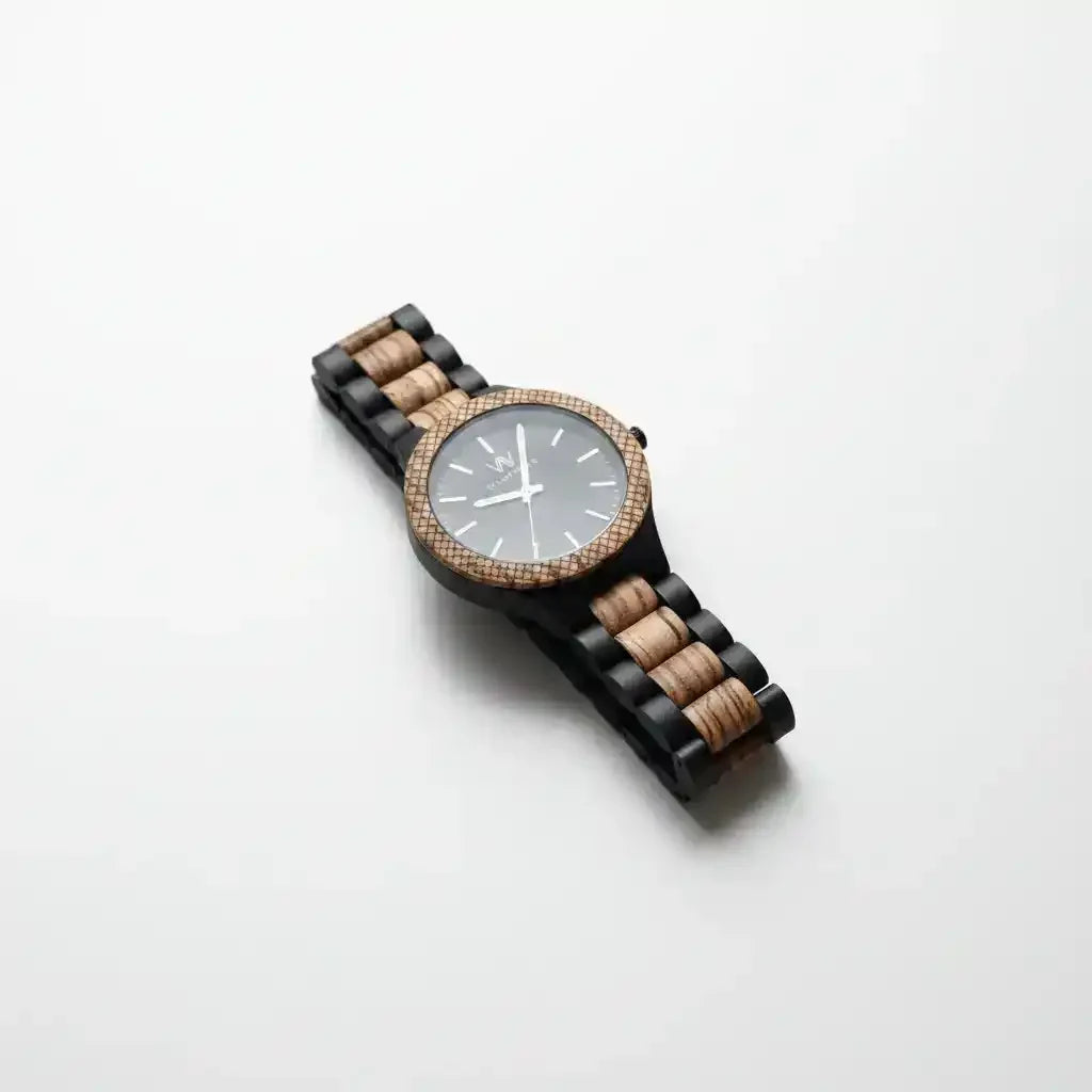 Wooden watch with black and natural wood band, gray dial, and textured bezel on white background