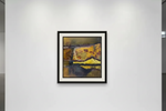 Framed abstract landscape print with yellow and dark tones, displayed on white gallery wall