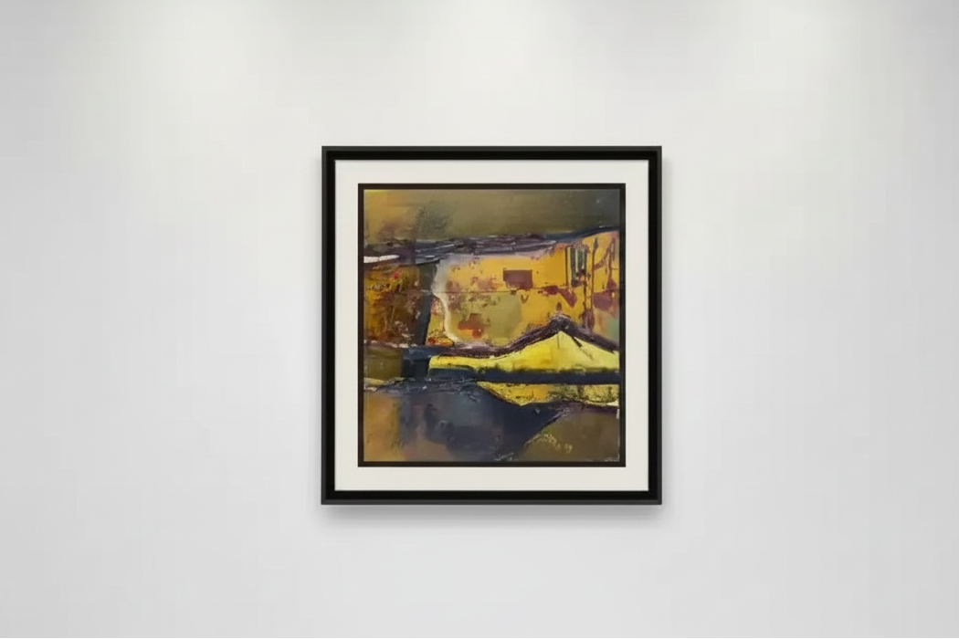 Framed abstract landscape print with yellow and dark tones, displayed on white gallery wall