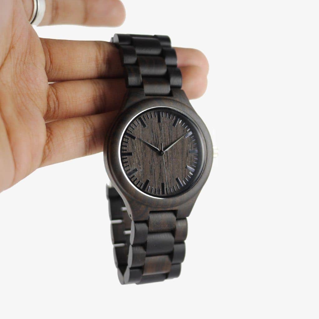Wooden watch held in a hand against a white background