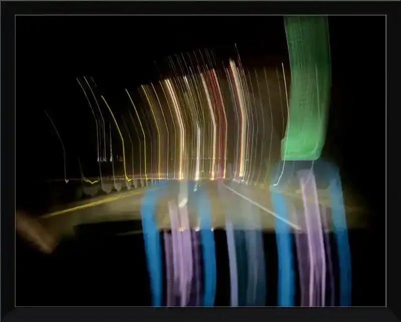 Abstract night road light trails in motion, colorful streaks on dark pavement, framed art print
