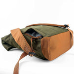 Olive green and tan canvas backpack with adjustable straps and open top pocket