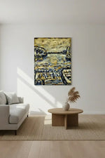 Framed coastal artwork with boats and rocky shore, displayed in modern living room