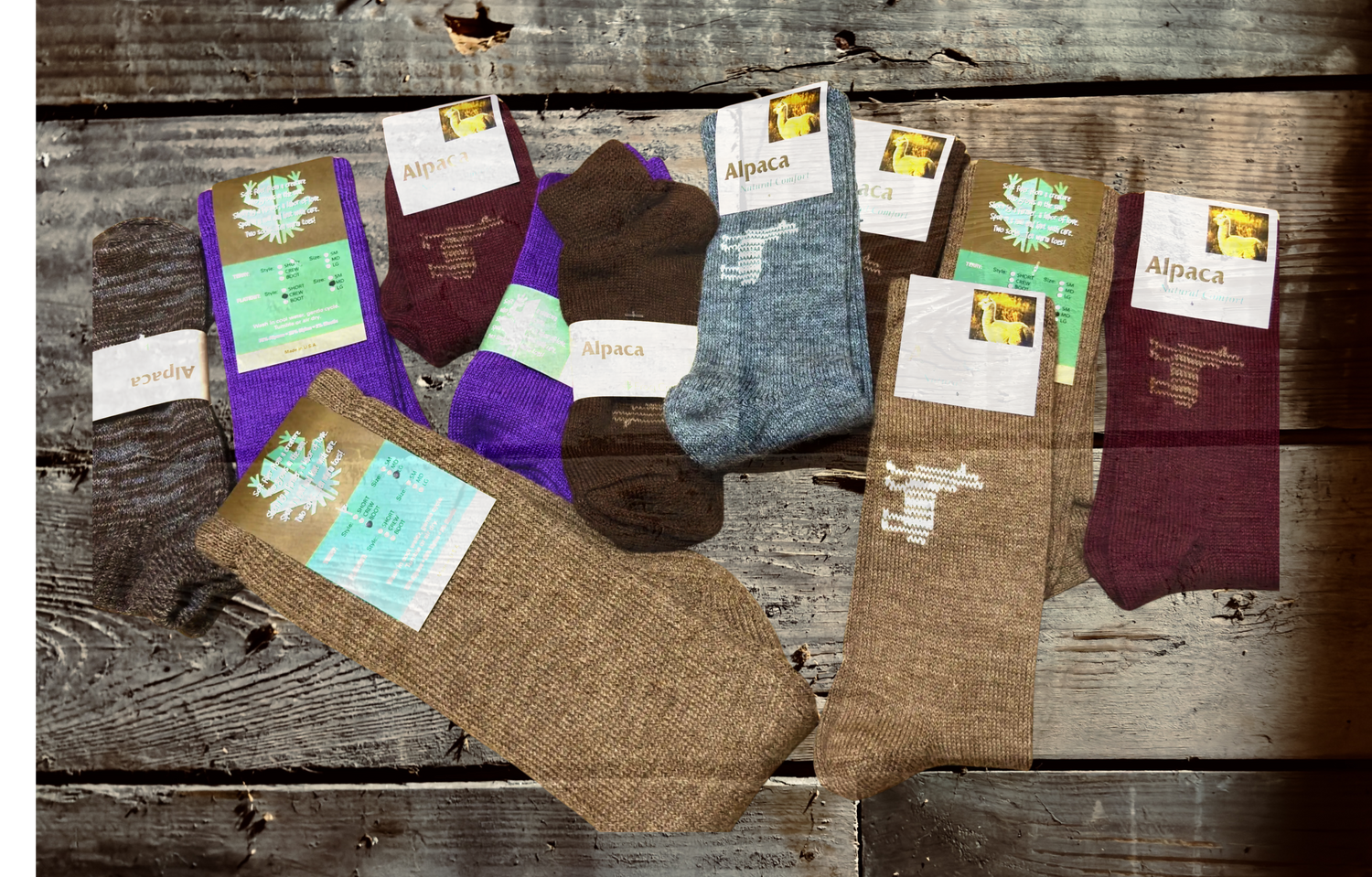 Collection of various colored socks with labels on a wooden surface