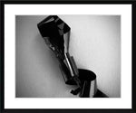 Black and white framed print of abstract metallic sculpture against textured wall