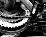 Black and white close-up of vintage bicycle gears and chain, showcasing mechanical texture and detail