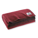 Folded red blanket with a brand label on a white background