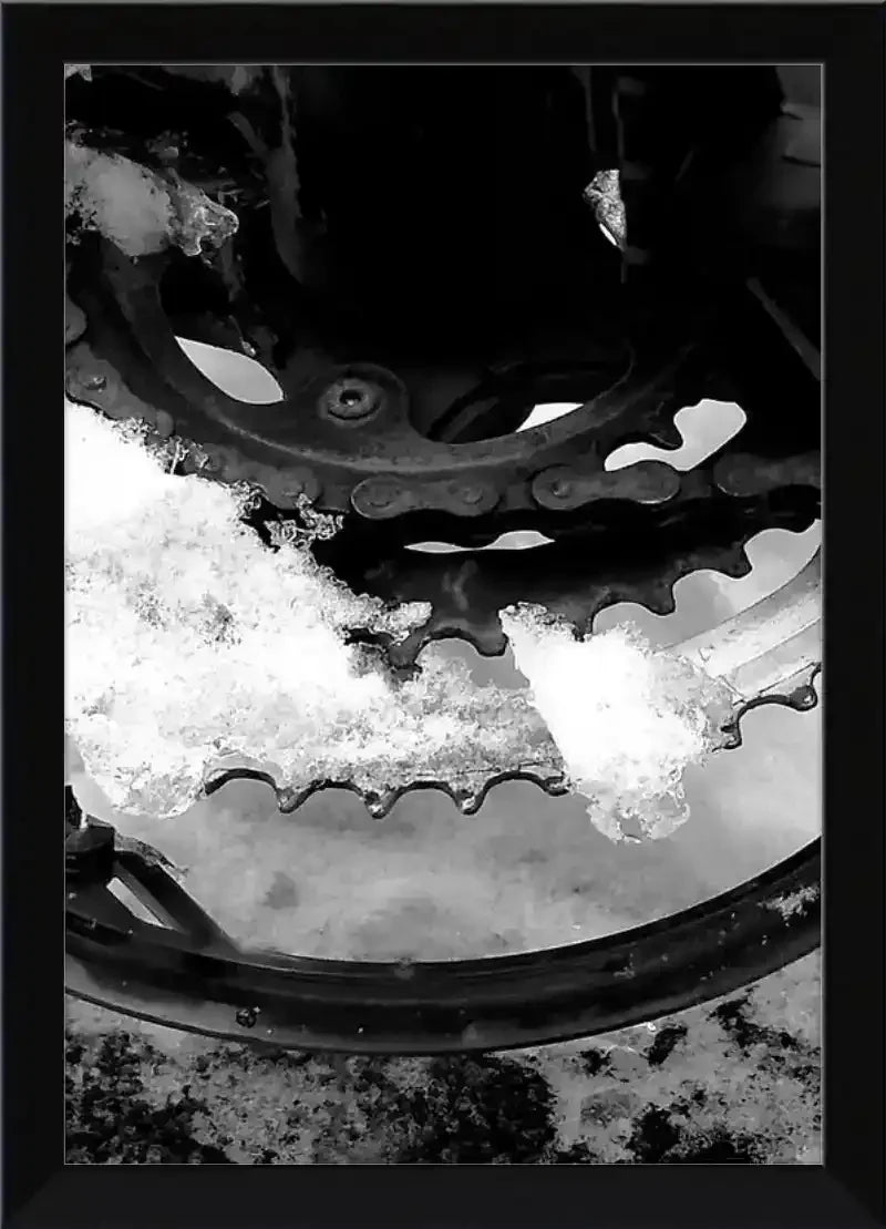 Snow-covered bicycle gear and chain in black and white, framed print