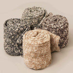 Four skeins of yarn in different colors on a neutral background