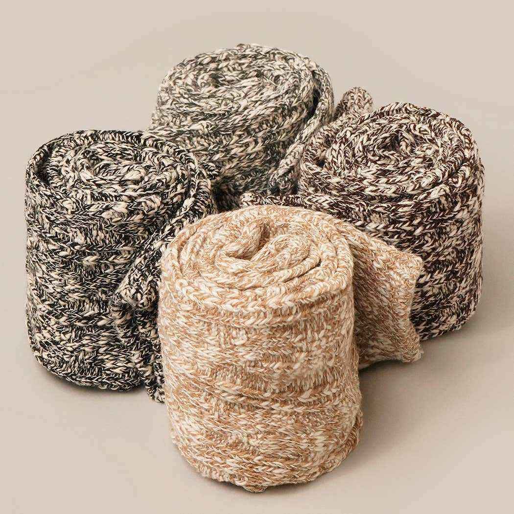 Four skeins of yarn in different colors on a neutral background
