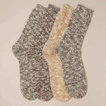 Two pairs of marled socks in gray and beige on a beige background