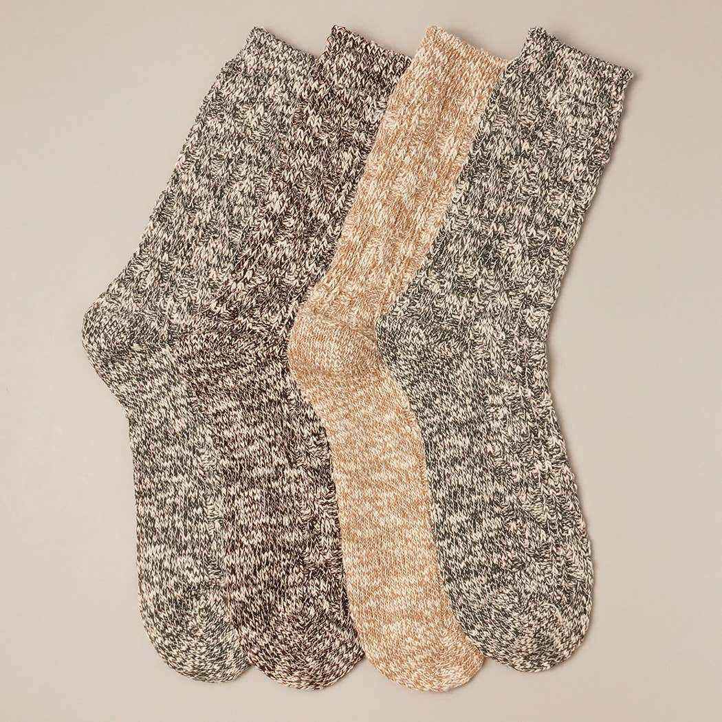 Two pairs of marled socks in gray and beige on a beige background