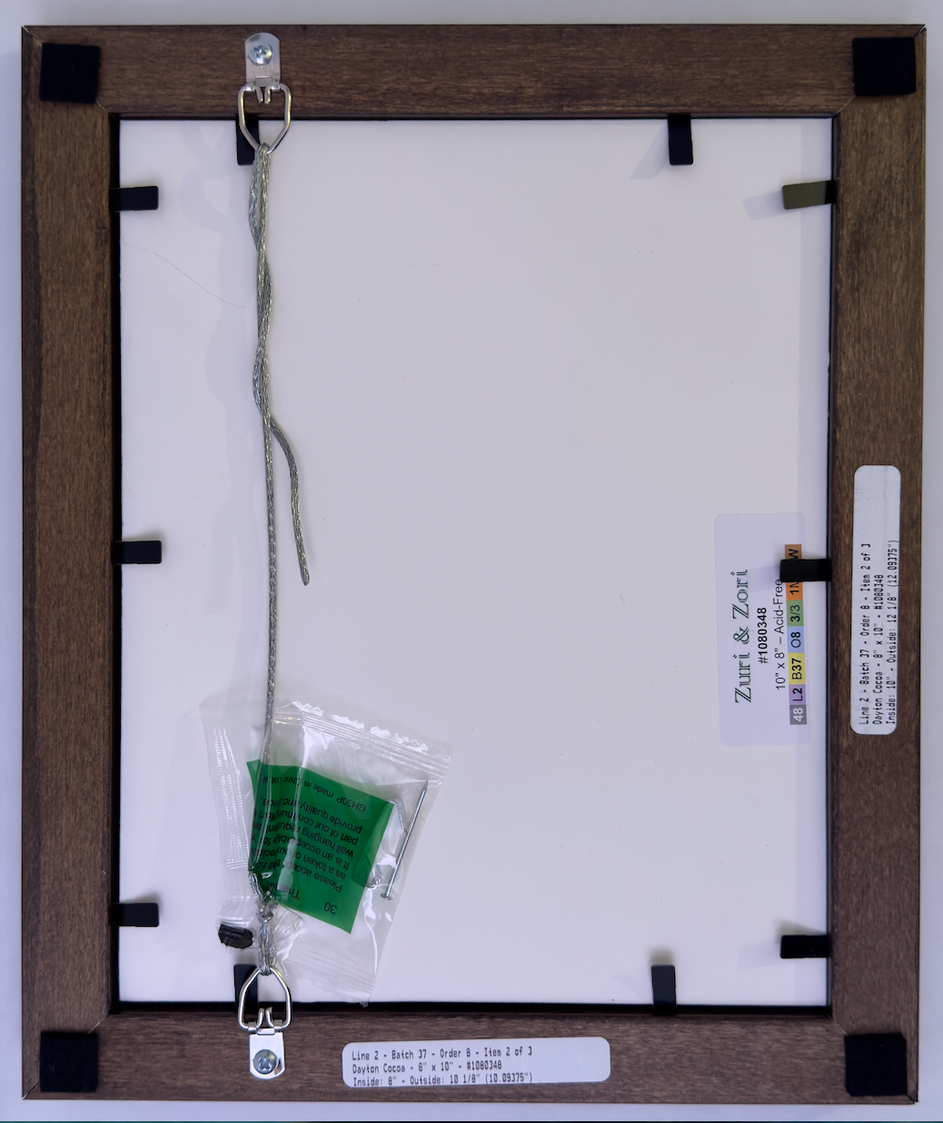 Back view of a Picture Frame with a Zuri & Zori label and hanging components. 