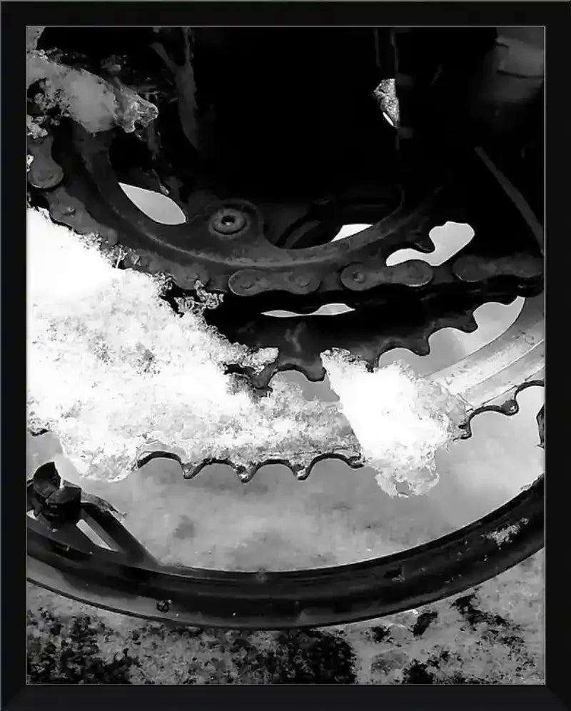Snow-covered bicycle gear and chain in black and white, framed print