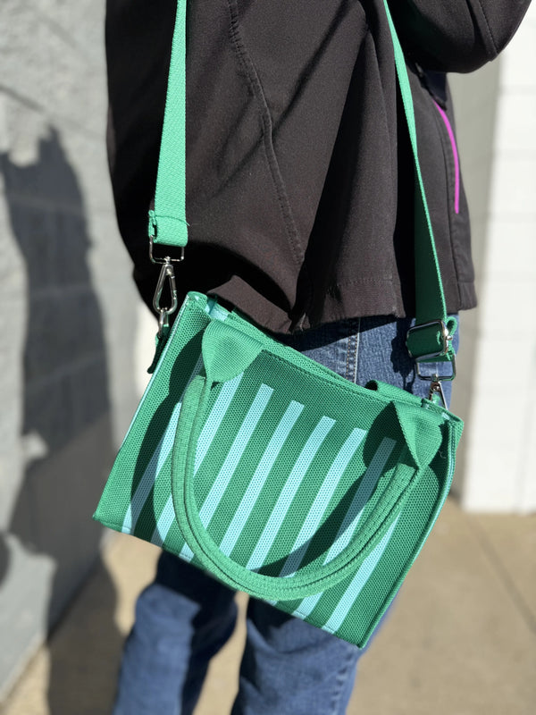 Green and aqua mini tote being worn in the sun