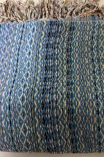 Close-up of a textured fabric with a blue and multicolor pattern