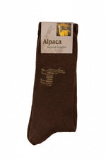 Brown alpaca sock with label on a beige background