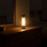 Glowing lantern on wooden dresser in dim room, warm ambient light