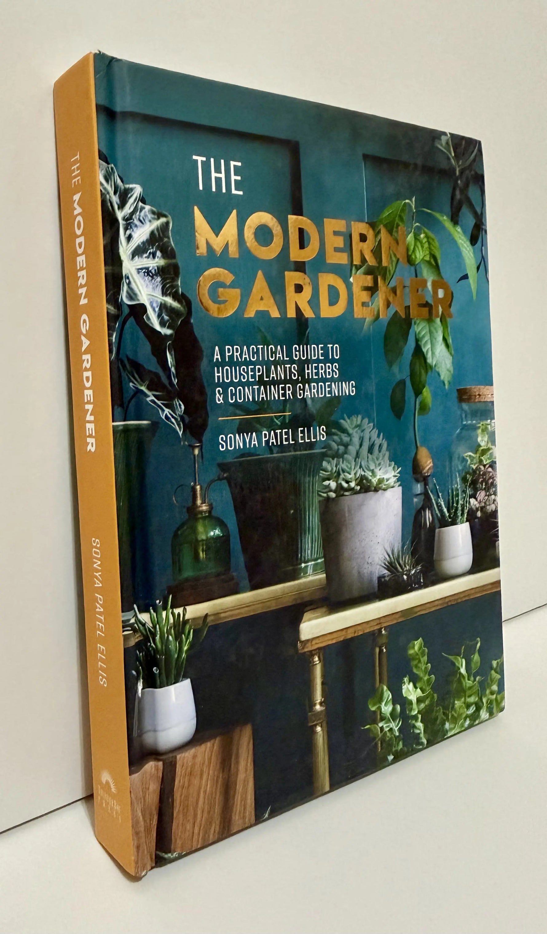 Side of book titled 'The Modern Gardener' on a white surface