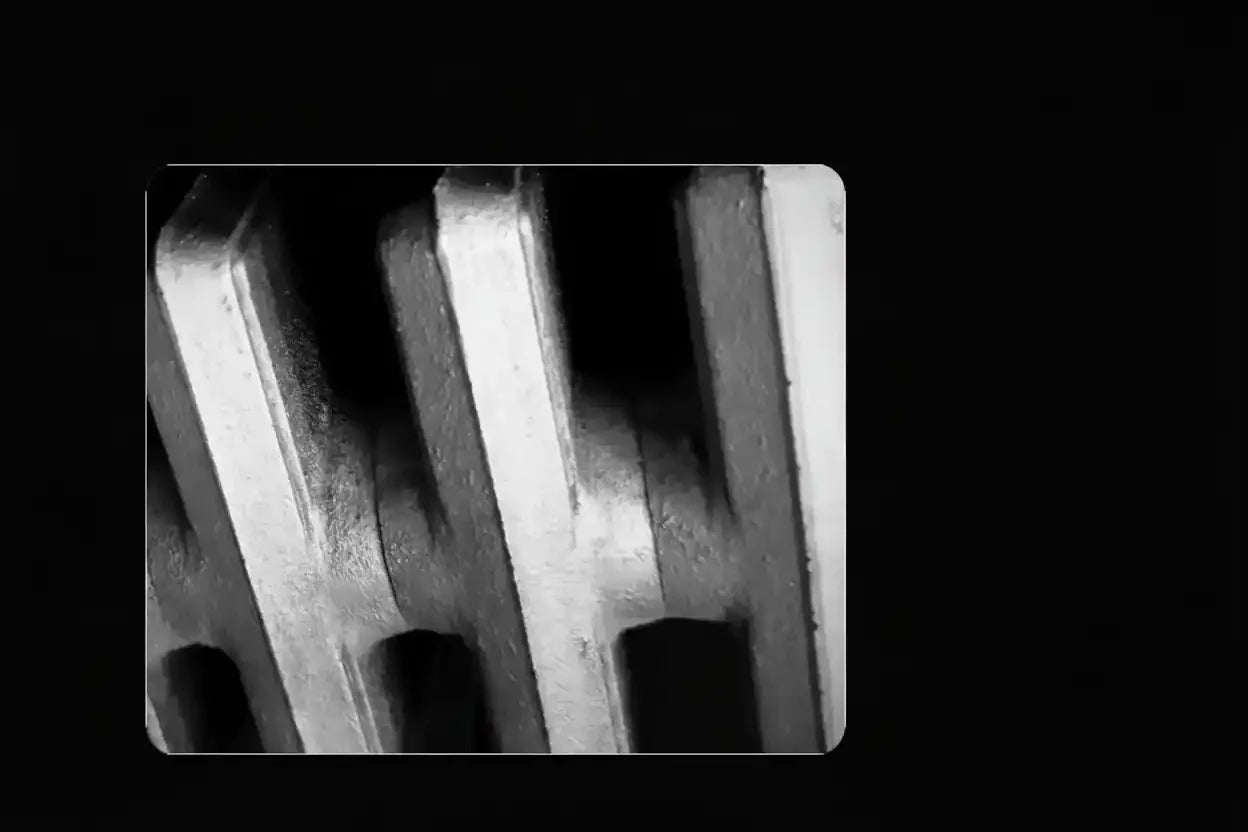 Close-up of textured metal grate with geometric shadows, monochrome industrial photography