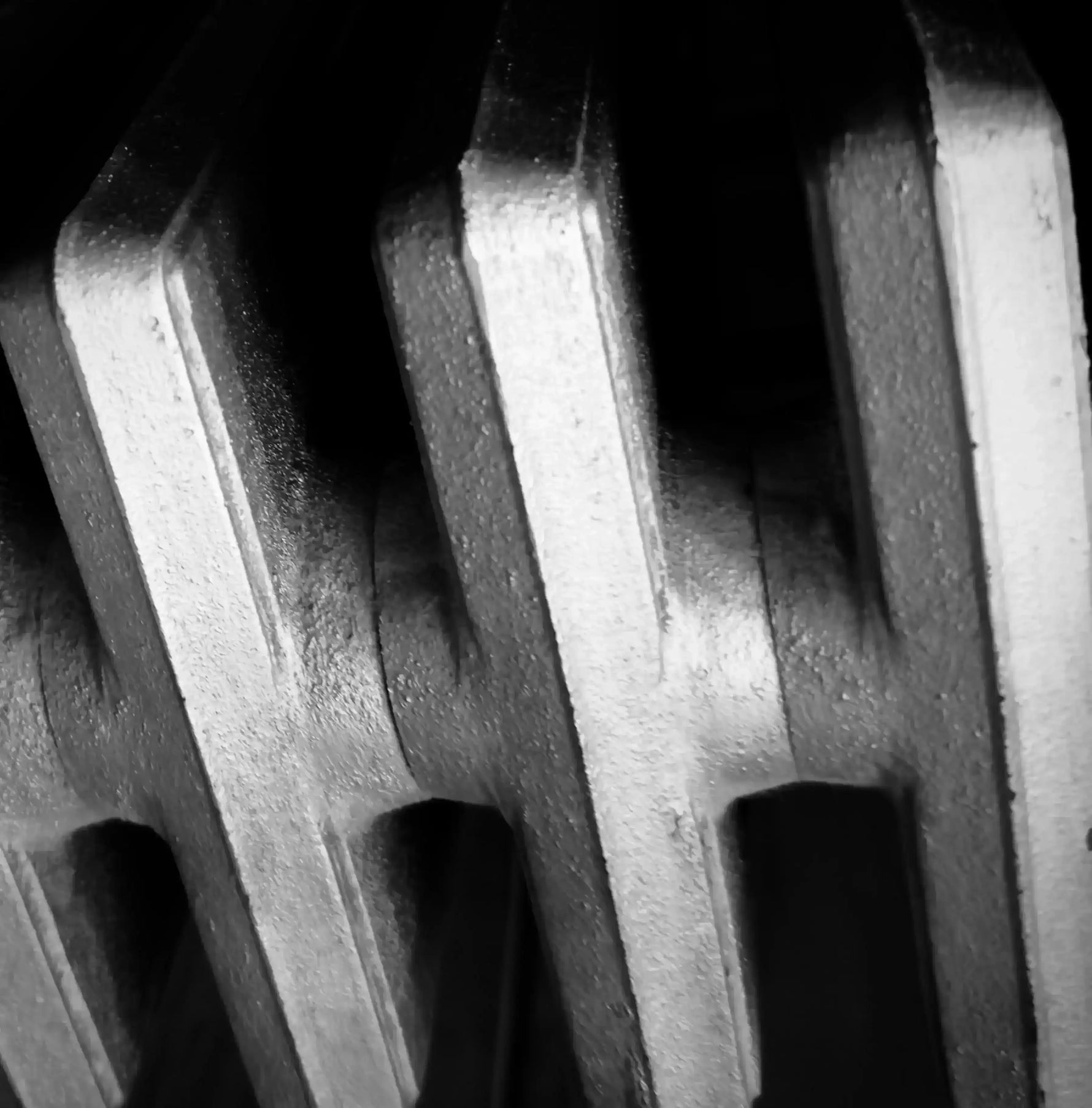 Black and white abstract close-up of textured vertical ridges and shadows