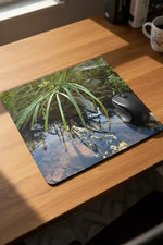 Nature photography mouse pad with stream, rocks, and green reeds on wooden desk