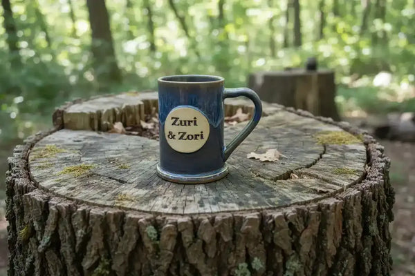 Zuri & Zori ceramic mug on tree stump in forest, rustic outdoor setting