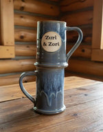Mugs Two blue ceramic mugs stacked on a wooden surface with 'Zuri & Zori' branding. mugs