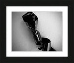 Black and white framed print of abstract metallic sculpture with reflective surfaces and textured wall background