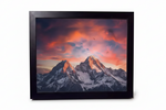 Framed mountain print with sunset sky, snow-capped peaks, dramatic clouds — nature photography wall art