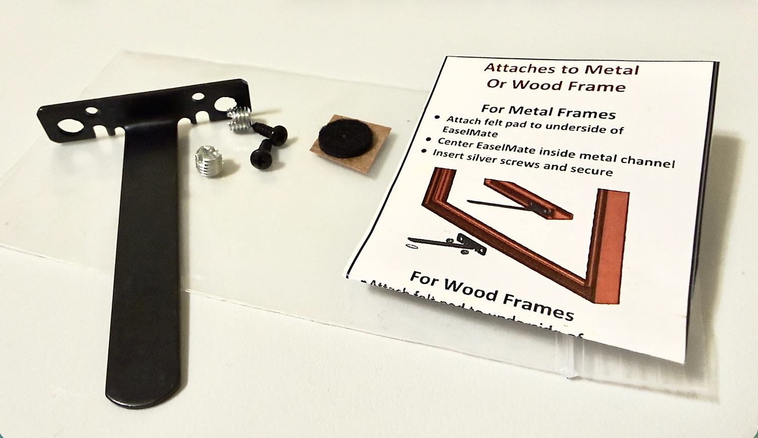 Metal bracket, screws, felt pad, and instructional card on a white background