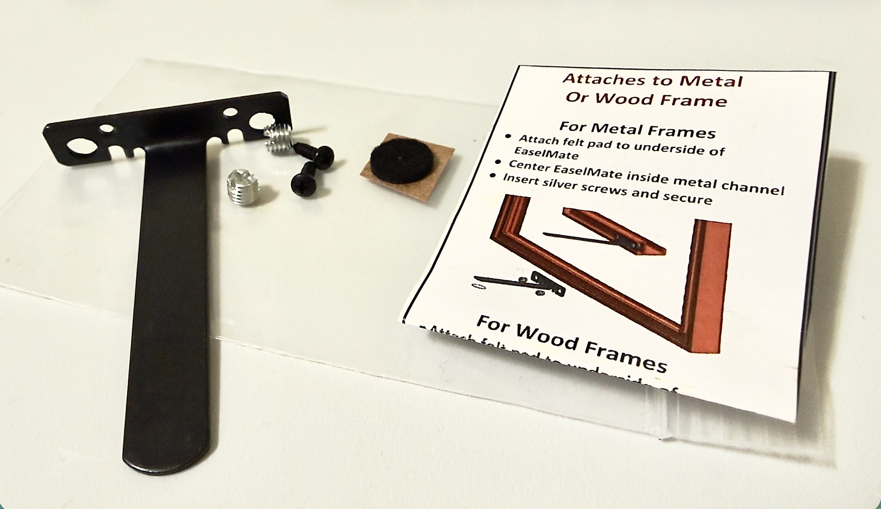 Metal bracket, screws, felt pad, and instructional card on a white background