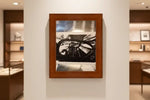 Framed black and white abstract artwork with geometric shapes, displayed on a gallery wall.