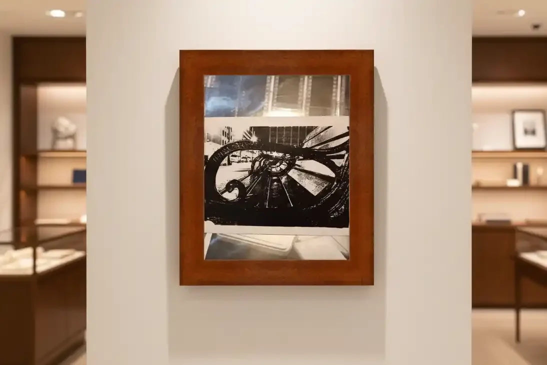 Framed black and white abstract artwork with geometric shapes, displayed on a gallery wall.
