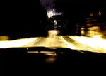 Nighttime road view from car headlights, wet pavement reflecting light, blurred motion