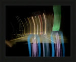 Framed abstract night light trails photo with motion blur, colorful streaks on dark background