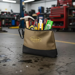 Tan and black Ryker tool pouch filled with pliers, screwdrivers, and tools in a garage workshop