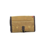 Tan waxed canvas roll-up pouch with dark brown trim, brass grommets, and leather strap closure, USA flag tag.