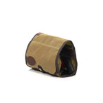 Tan waxed canvas toiletry bag with mesh interior and leather accents, ideal for travel organization