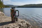 Tumbler with fish hook designs on a rock overlooking water Tumblers