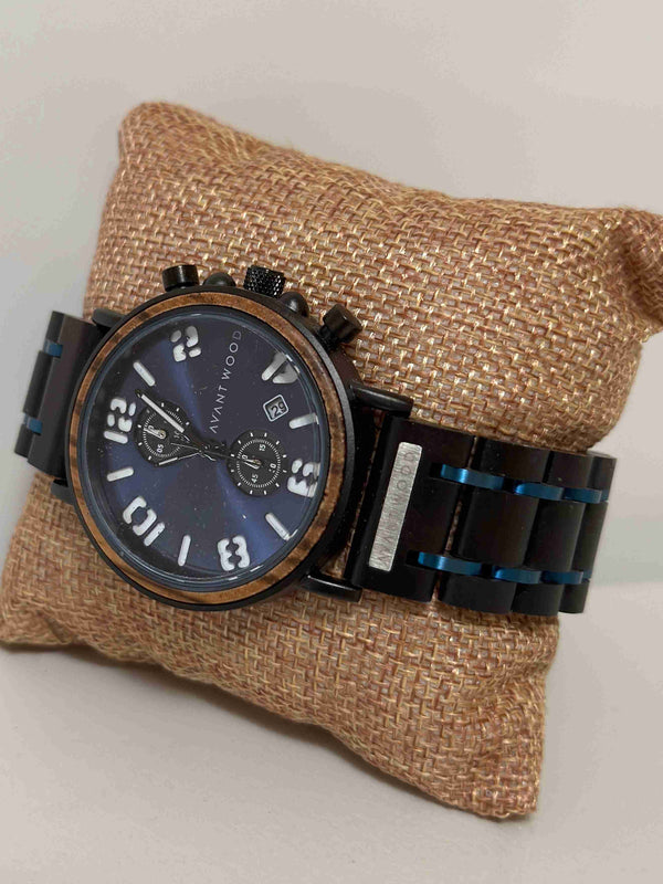 Watch with black strap and blue face on a textured brown pillow