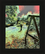 Framed surreal garden print with vibrant colors, wooden swing, and figure under red sky