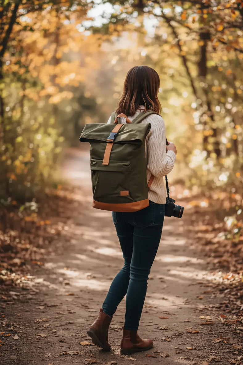 Woman with camera and backpack walking on autumn forest path, golden leaves, natural world photography