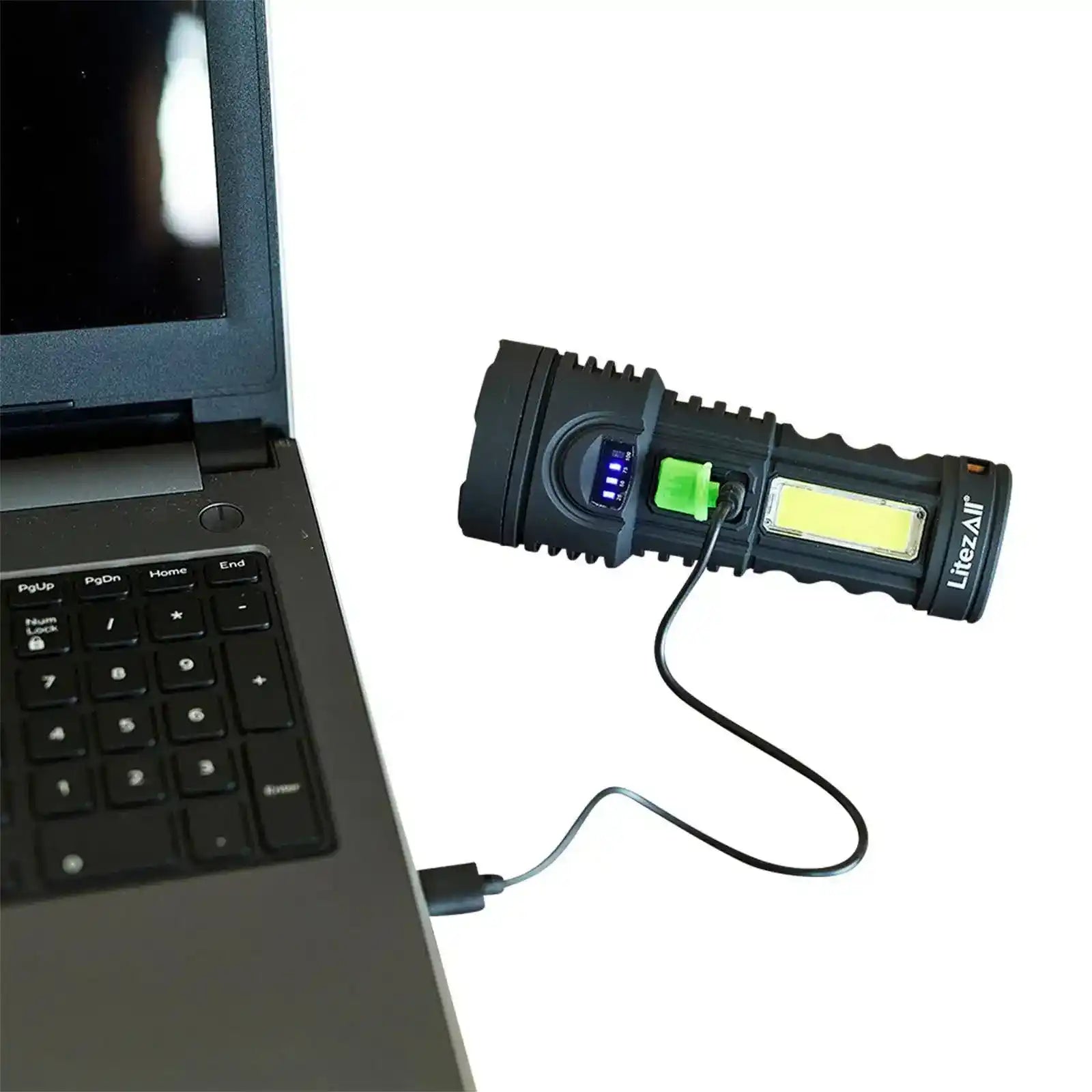 Black LitezAll COB LED flashlight charging via USB cable connected to laptop, showing battery level indicator.